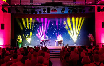 Boogie Woogie mit Nicola Senn und Elias Bernet mit farbiger Effekt–Beleuchtung im Hintergrund der Bühne