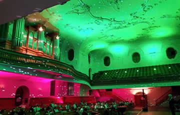 Die Decke mit LED-Scheinwerfer grün, die Wände unten mit Astera LED Akku-Scheinwerfer AX7 rot und zusätzlich mit Spiegelkugel 
                                weiss beleuchtet