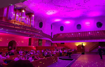 Decke in hellviolett, Wände unten pink mit LED-Scheinwerfern angestrahlt, zusätzlich mit Spiegelkugeleffekt beleuchtet