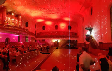 Decke in rot, unter der Orgel pink mit LED-Scheinwerfern angestrahlt, zusätzlich mit Spiegelkugel beleuchtet